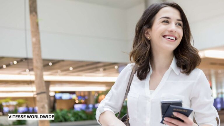 Smiling woman holding passport in airport.