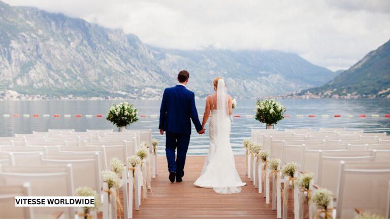 Couple walking down the aisle at a lakeside luxury destination wedding, having arrived there by private jet and chauffeured luxury vehicle, symbolizing elegant, first-class celebration travel.